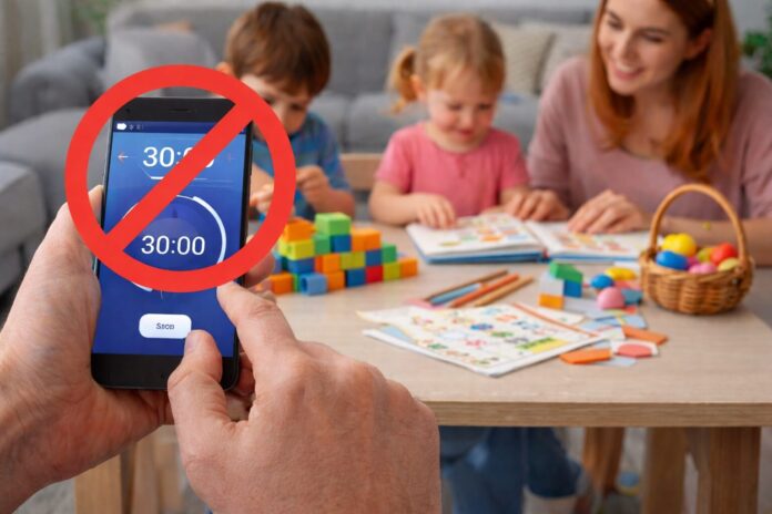 Çocuklarda ekran süresi nasıl azaltılır konusunu gösteren, telefon zamanlayıcısını kapatan ebeveyn ve arka planda oyun oynayan çocuklar